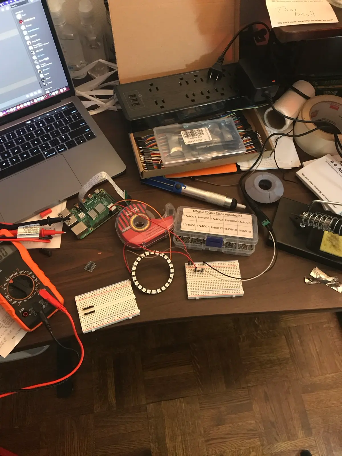NeoPixel ring wired up on the bench with breadboards and a multimeter